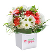 The spirit of spring is captured in this cheerful bouquet, arranged with heartfelt attention by Woodford Florist just steps from Churchfields or Forest Approach. The main event: lush coral and peach carnations, their abundant, ruffled petals brimming with soft vibrance and subtle fragrance. These blossoms are joined by perky white daisies with radiant, lime-yellow centers-each flower shining brightly against a sea of lush green foliage reminiscent of Woodford's cherished local parks. Threading through the arrangement, delicate clouds of baby's breath add a gossamer lightness, while a few purple-tinged buds hint at new beginnings and the promise of tomorrow. All flowers nestle within a clean, bright white gift bag with elegant handles, ready to delight as a birthday surprise, a congratulatory offering, or a spontaneous gesture of friendship. Every stem is chosen with care and presented beneath gentle, diffused light, highlighting their freshness and vibrant hues. This bouquet is a testament to thoughtful floristry-bringing a smile and a breath of Woodford's uplifting atmosphere into any home.